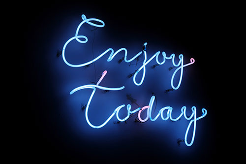 Neon "Enjoy today" on black background