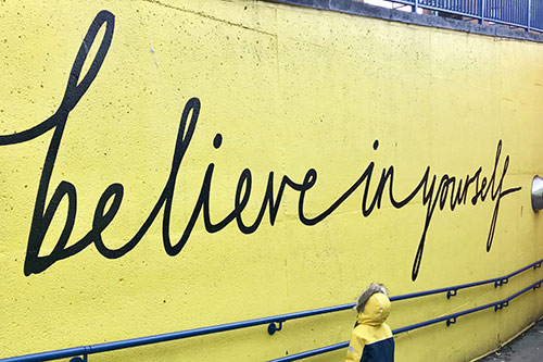 text on yellow wall "Believe in yourself"